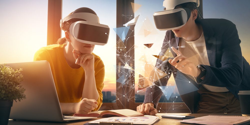 Due persone con visori di realtà virtuale che interagiscono con un modello 3D.